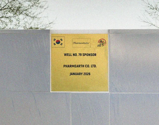A brass plaque reading “Well No. 79 Sponsor, Pharmearth Co. Ltd., January 2026” mounted on the well wall beside a Korean flag